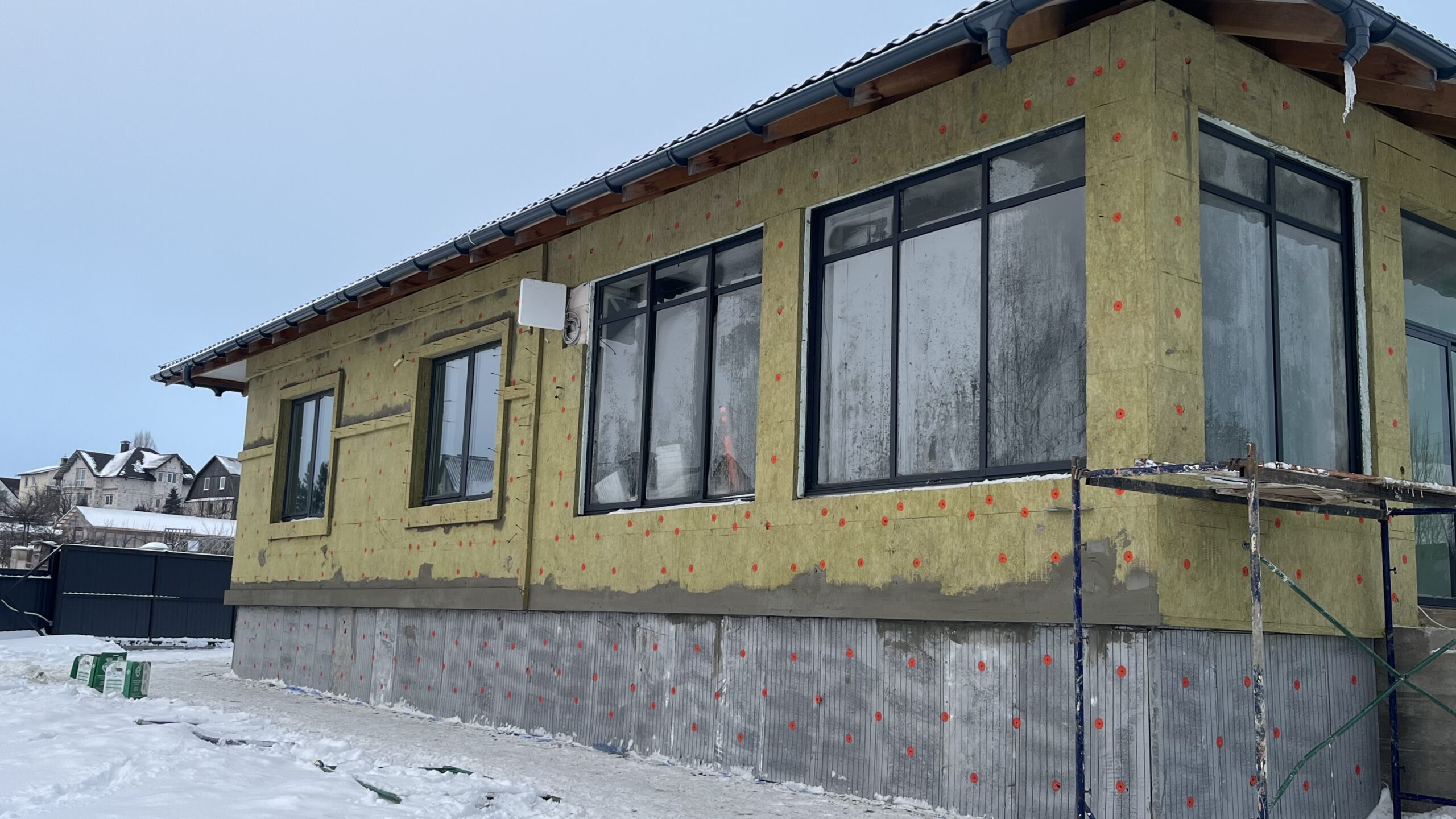 Этап утепления фасада дома с минеральной ватой и облицовкой